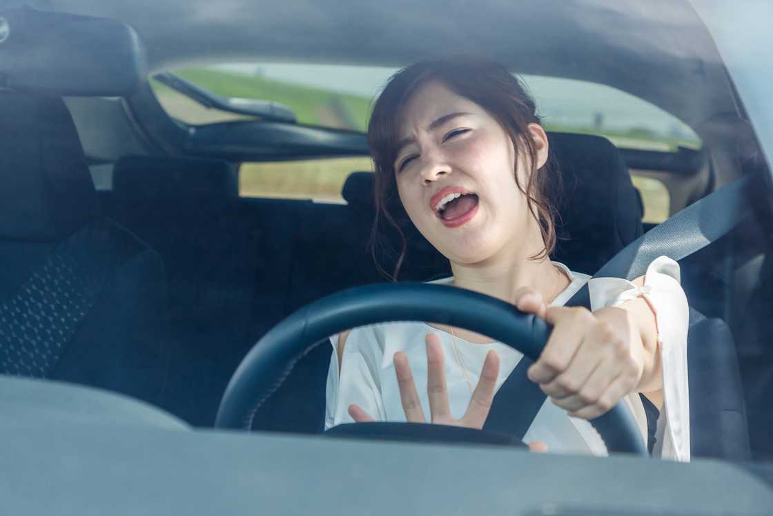 A young woman getting annoyed while driving a car A young woman getting annoyed while driving a car