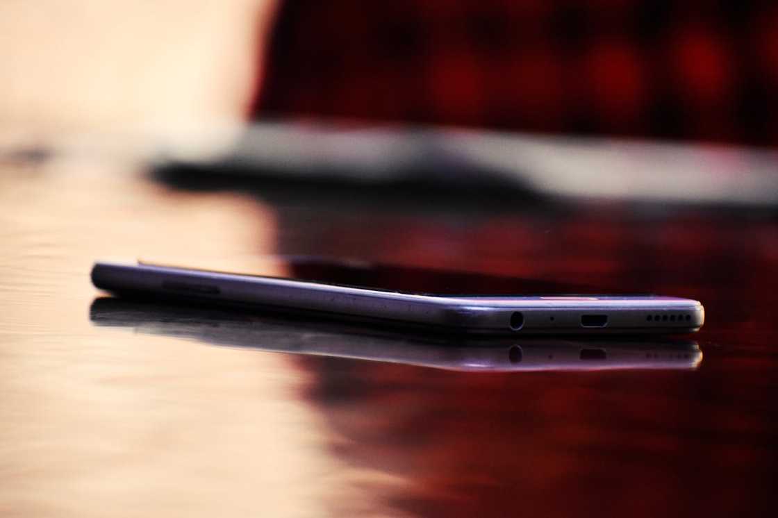 Smartphone lying on a wooden table surface. Smartphone lying on a wooden table surface.