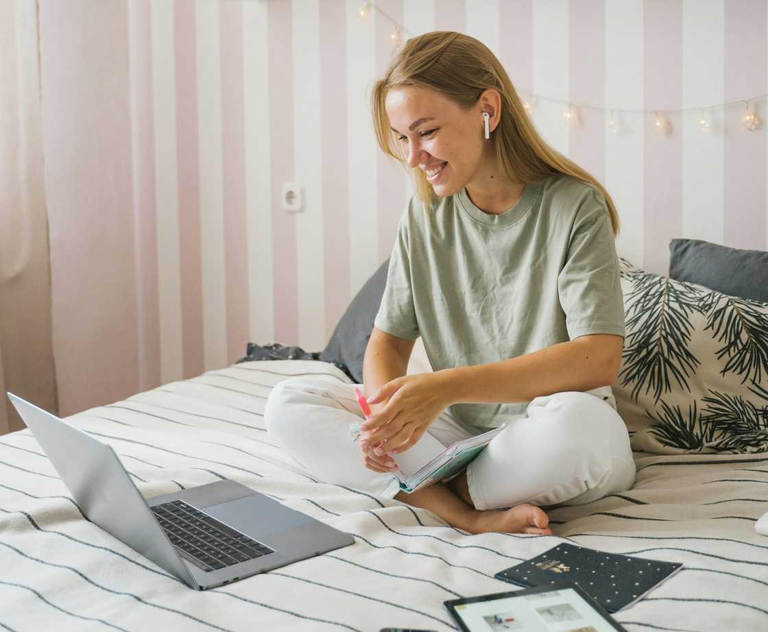 A woman on a video call while sitting on a bed