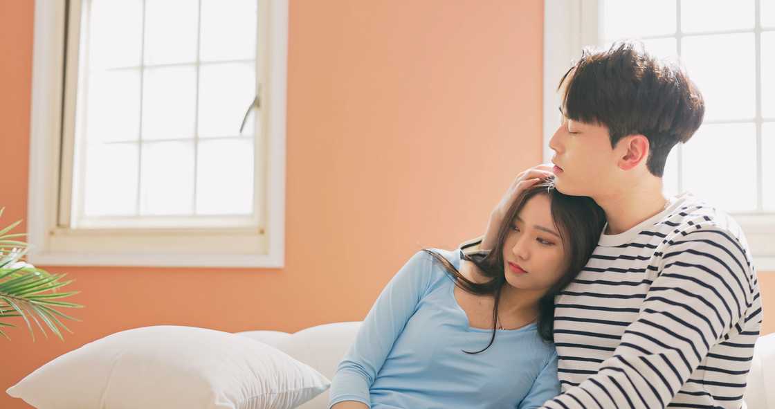 A man comforting his girlfriend at home A man comforting his girlfriend at home