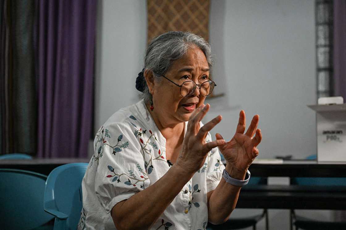An old woman talking and gesticulating with her hands An old woman talking and gesticulating with her hands