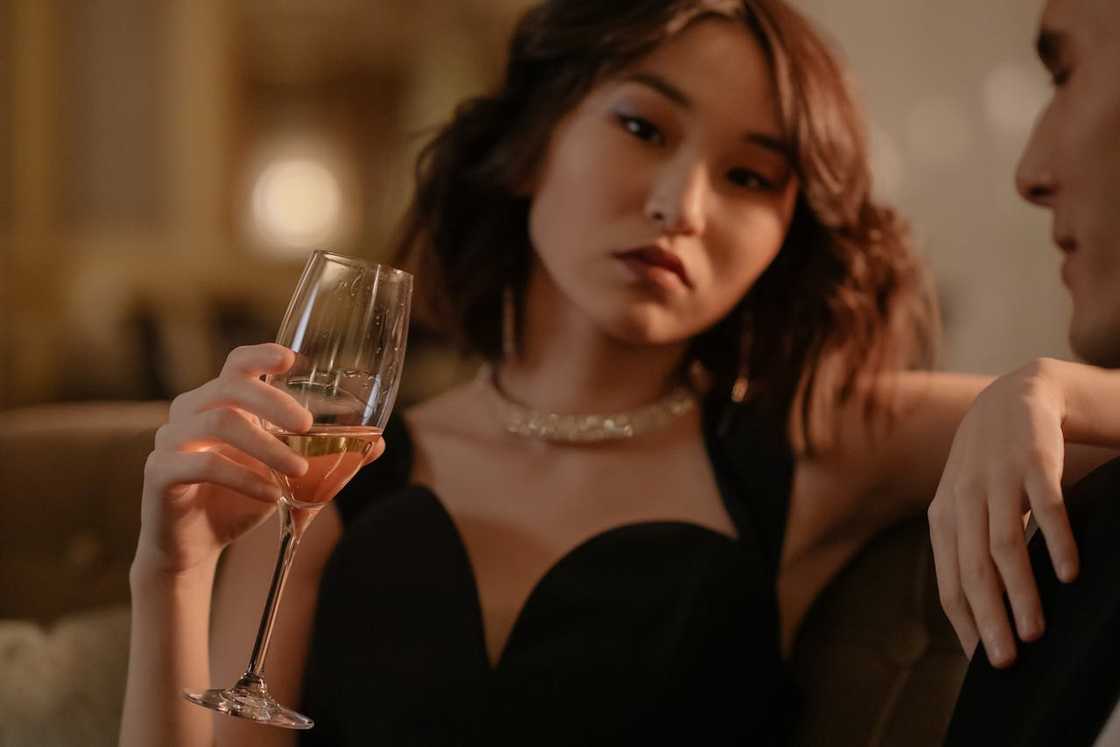 A woman holds a glass of wine during a date. A woman holds a glass of wine during a date.
