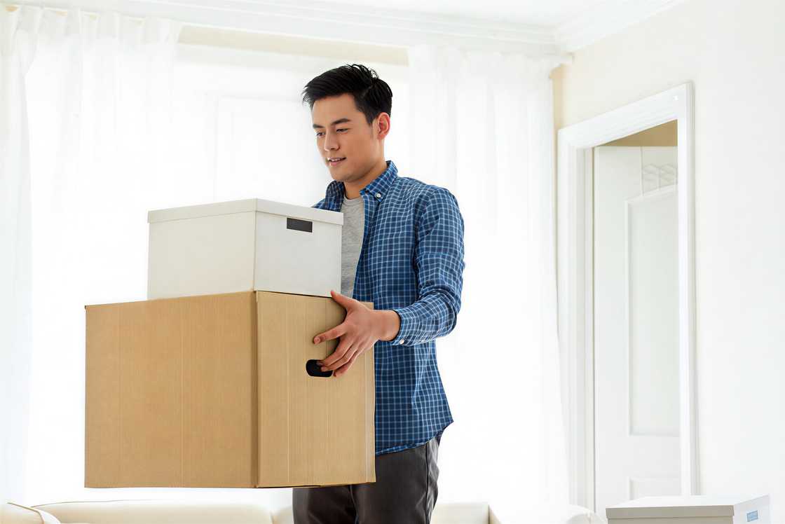A young man is carrying boxes