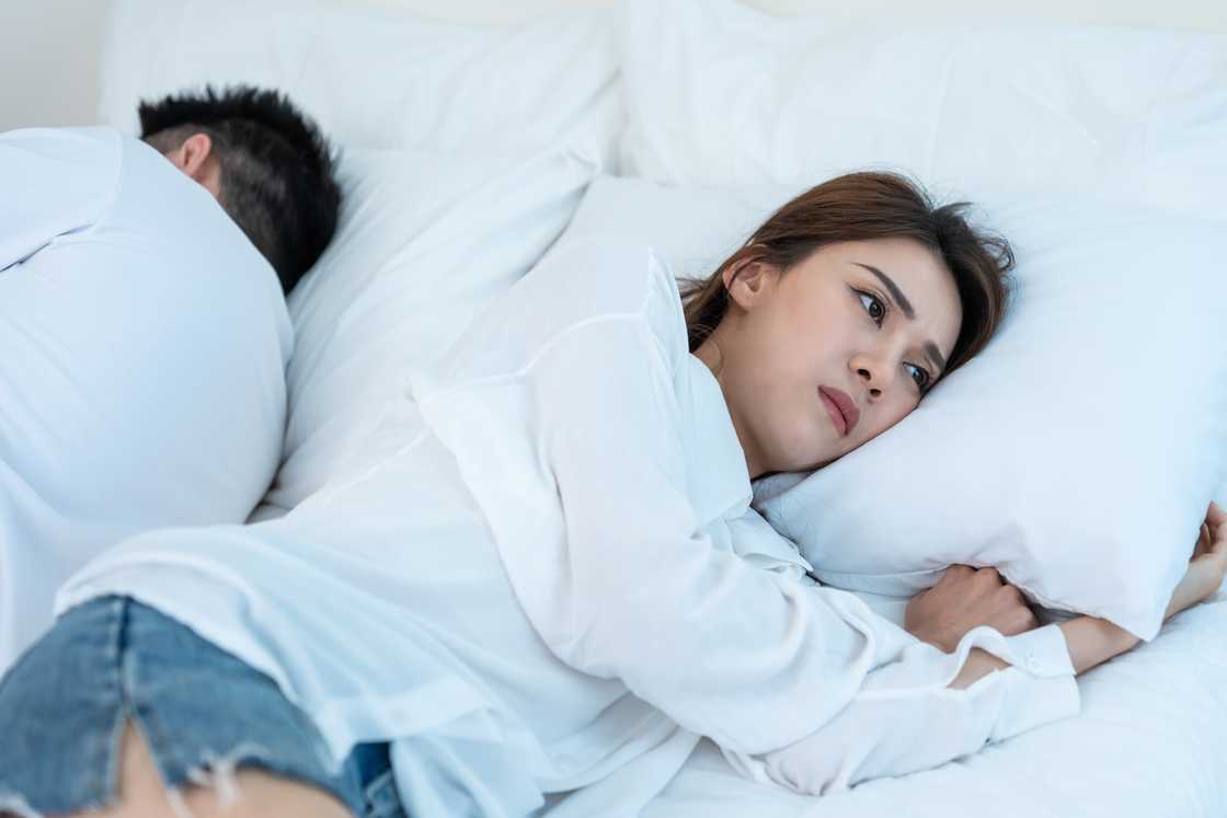 A woman sleeps next to her husband