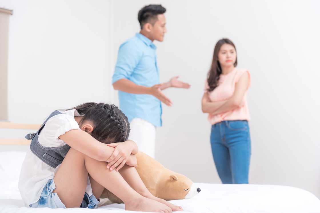 A man and woman arguing infront of a worried kid A man and woman arguing infront of a worried kid