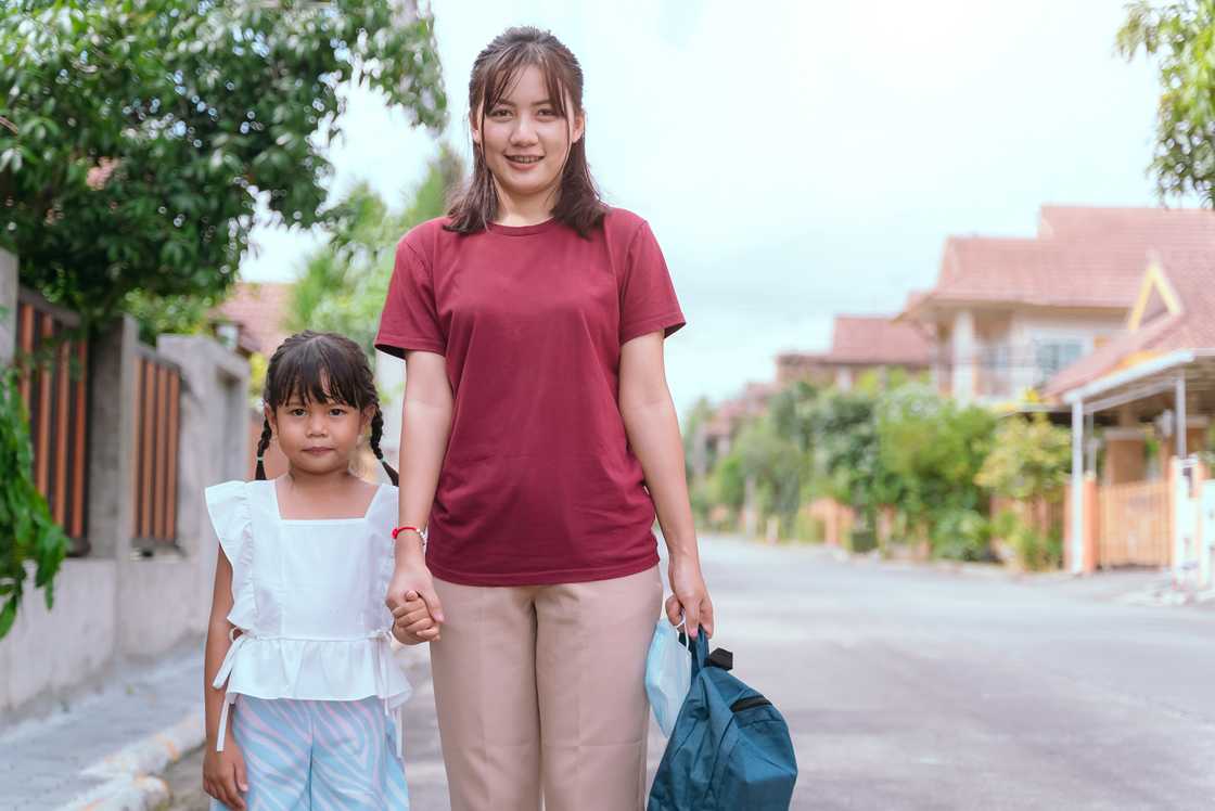 A caring mother escorting her daughter to school