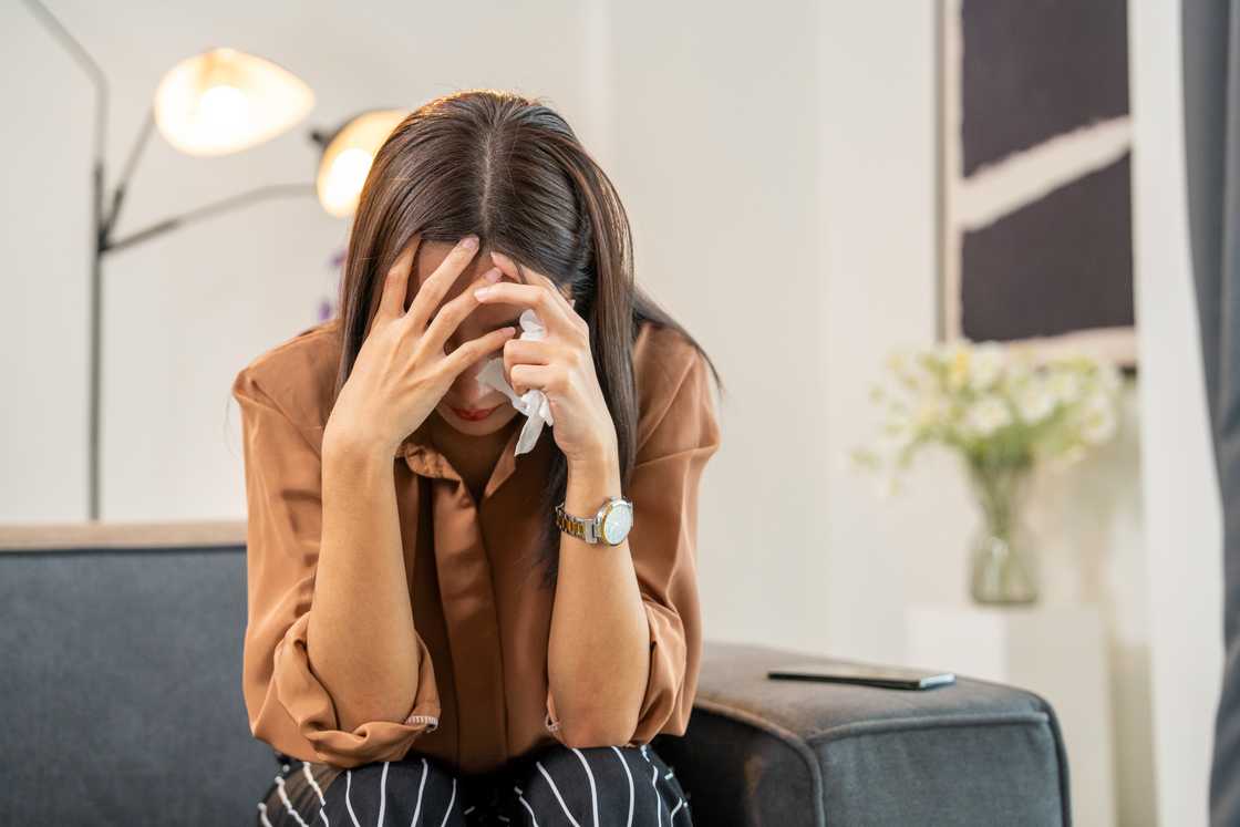 A stressed young woman is covering her face A stressed young woman is covering her face