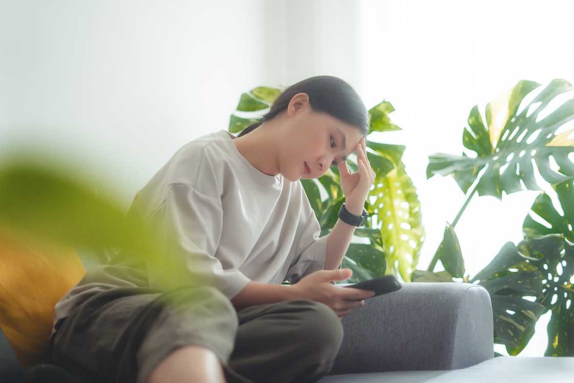 A disappointed woman looking at her phone