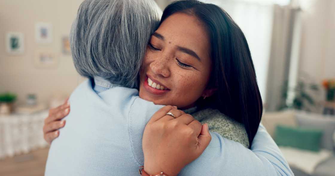 A mother and daughter-in-law are hugging