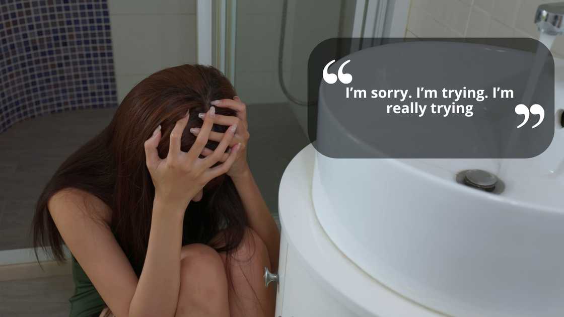 A woman sitting on bathroom floor feeling sad