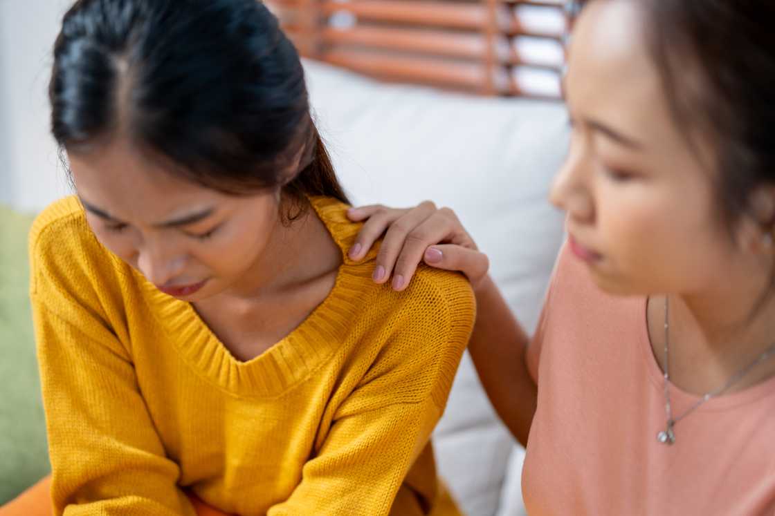 A woman is comforted by a friend A woman is comforted by a friend