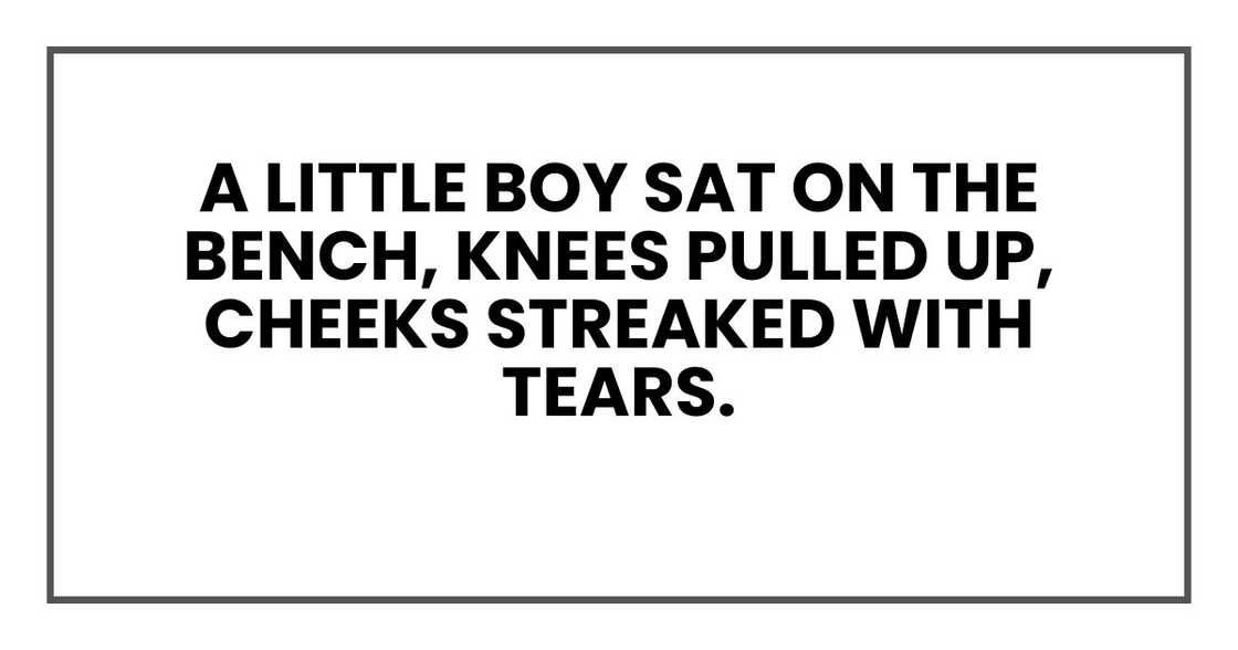 A little boy sat on the bench, knees pulled up