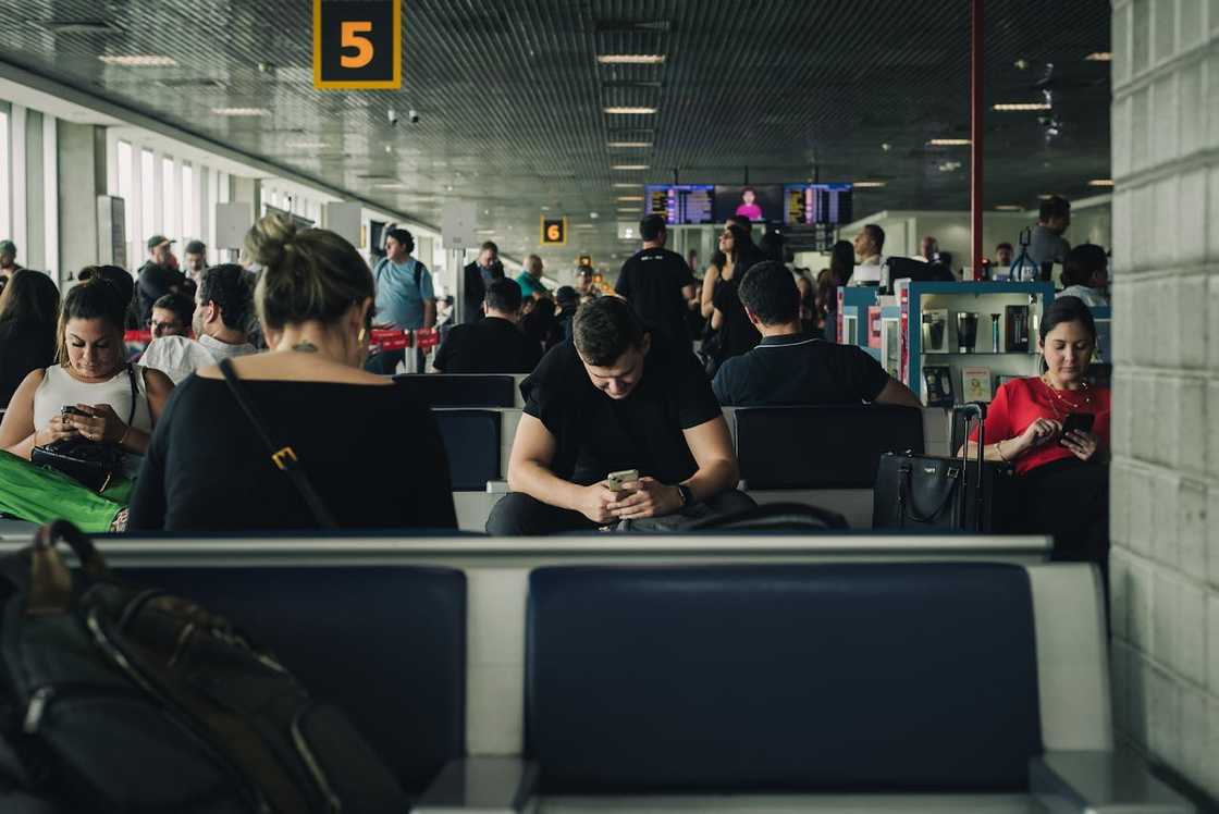 Grieving travellers, phones glowing with tragic updates.