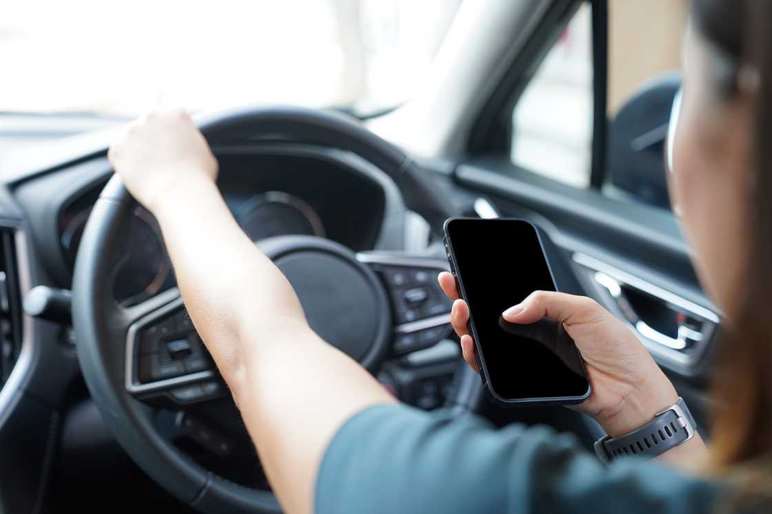 A lady is texting in the car A lady is texting in the car