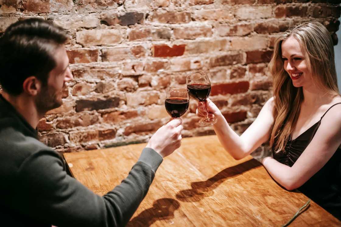 A couple enjoy a romantic dinner with wine at a table. A couple enjoy a romantic dinner with wine at a table.
