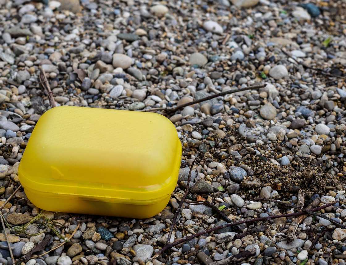 A yellow lunchbox on the ground