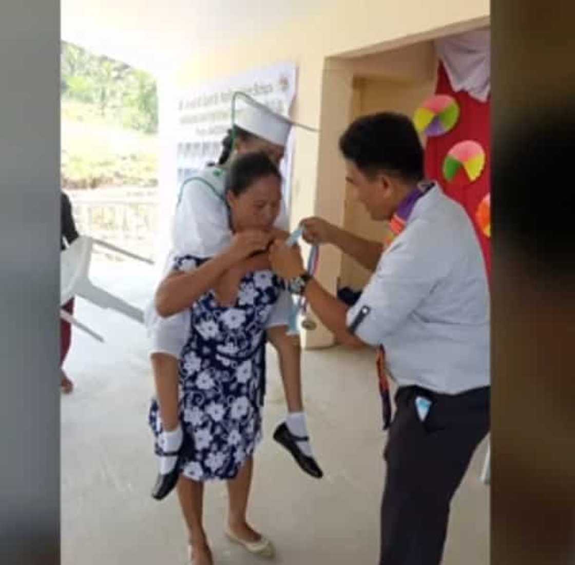 Ina, pinasan paakyat ng entablado ang anak na may kapansanan sa pagtanggap nito ng diploma sa kanyang Pagtatapos