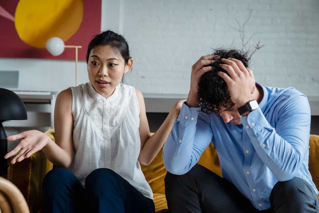 A woman confronts a man during an argument in a living room.