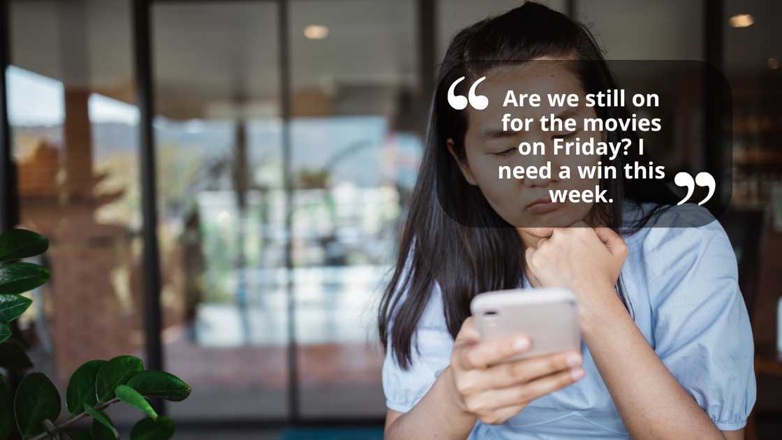 A sad woman looking at a message on her phone