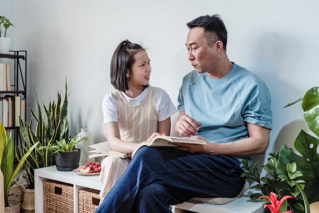 A father and daughter reading books. A father and daughter reading books.
