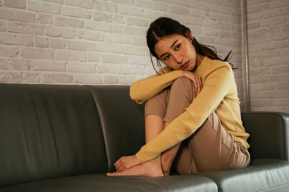 A worried woman sitting on the couch