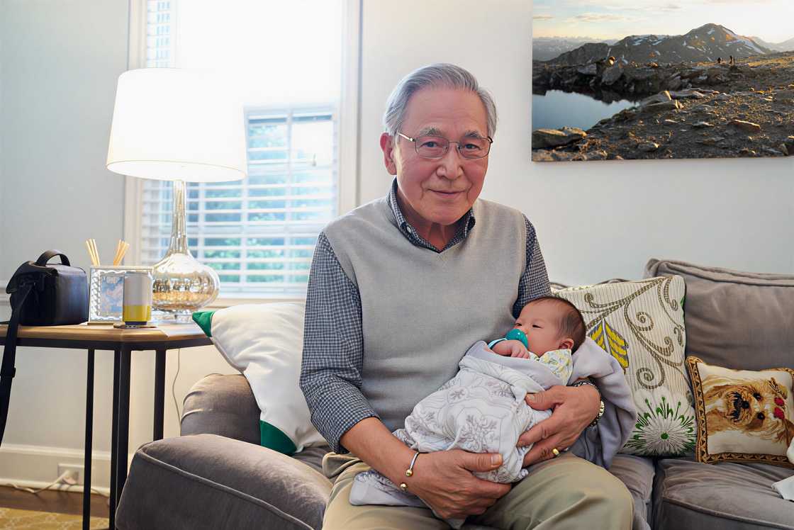Asian grandfather holding his grandson