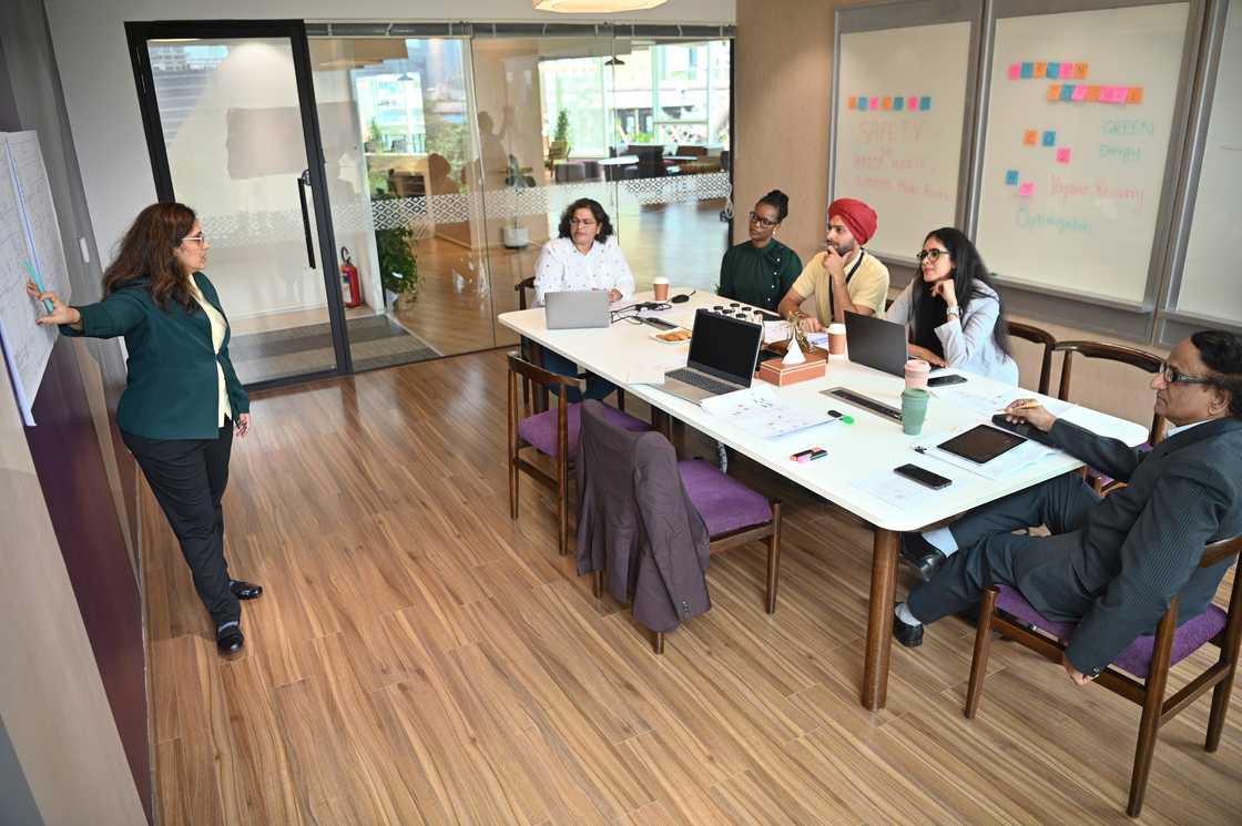 A trainer leads a session in a BPO office labelled "Clarity Lab." A trainer leads a session in a BPO office labelled "Clarity Lab."