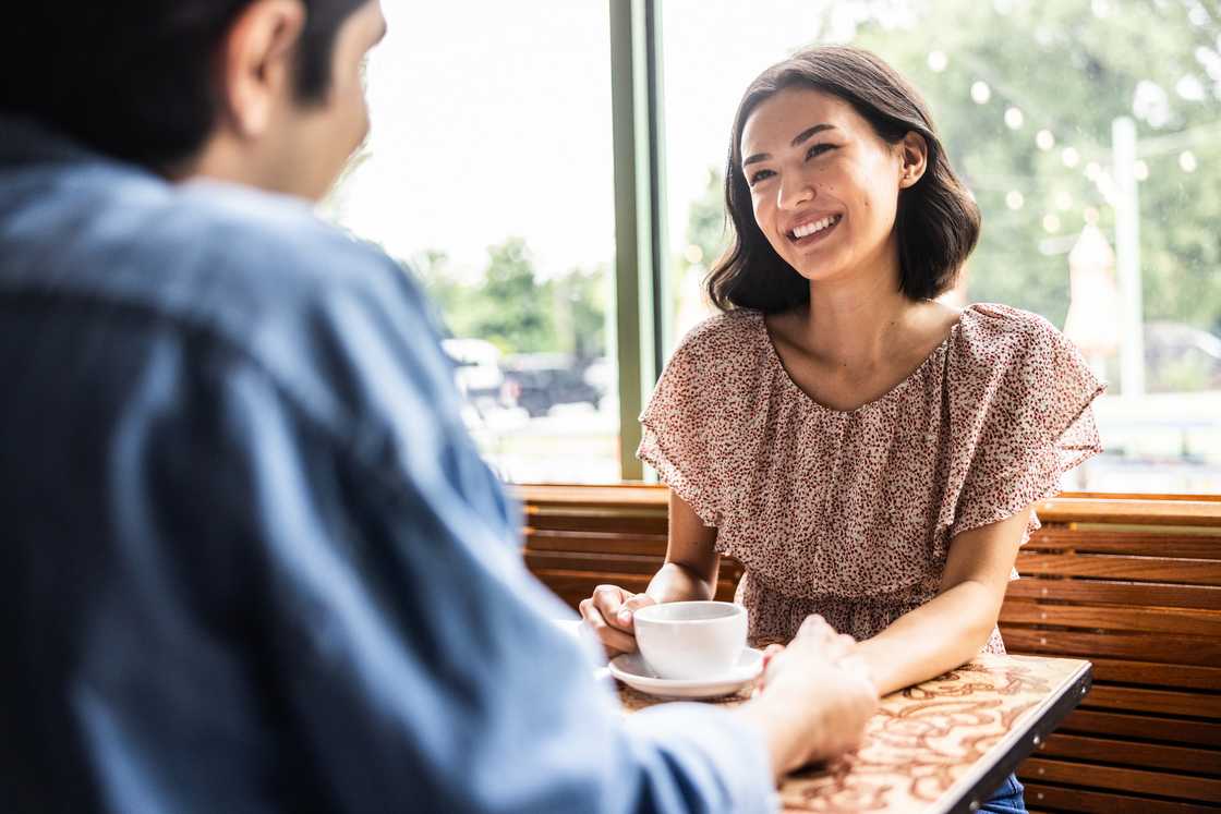 Young couple seated across from each other in a cafe Young couple seated across from each other in a cafe