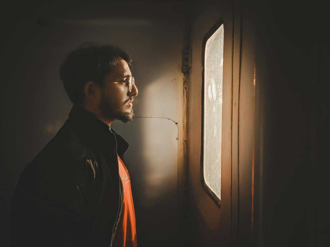 A sad man looks outside the window reflecting A sad man looks outside the window reflecting