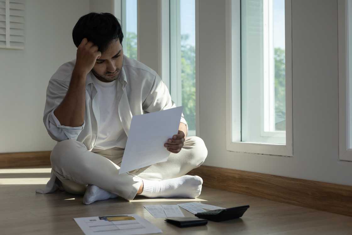 A stressed man looking at bills A stressed man looking at bills