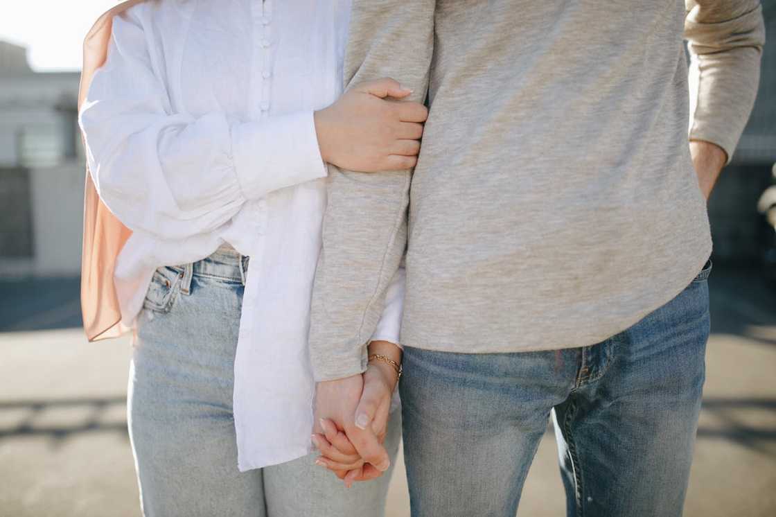 Close-up of two people holding hands outdoors. Close-up of two people holding hands outdoors.