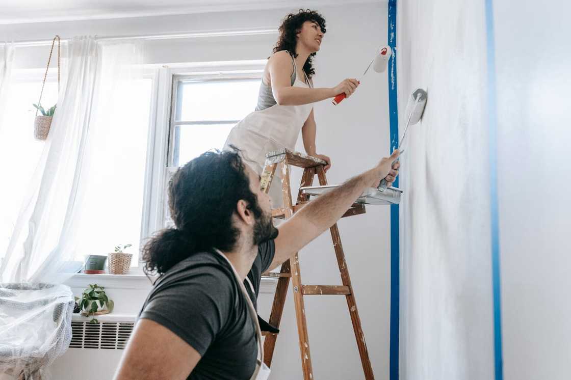 A couple painting their small apartment. A couple painting their small apartment.