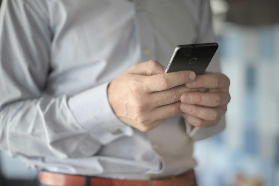 Hands holding a smartphone, typing a message.