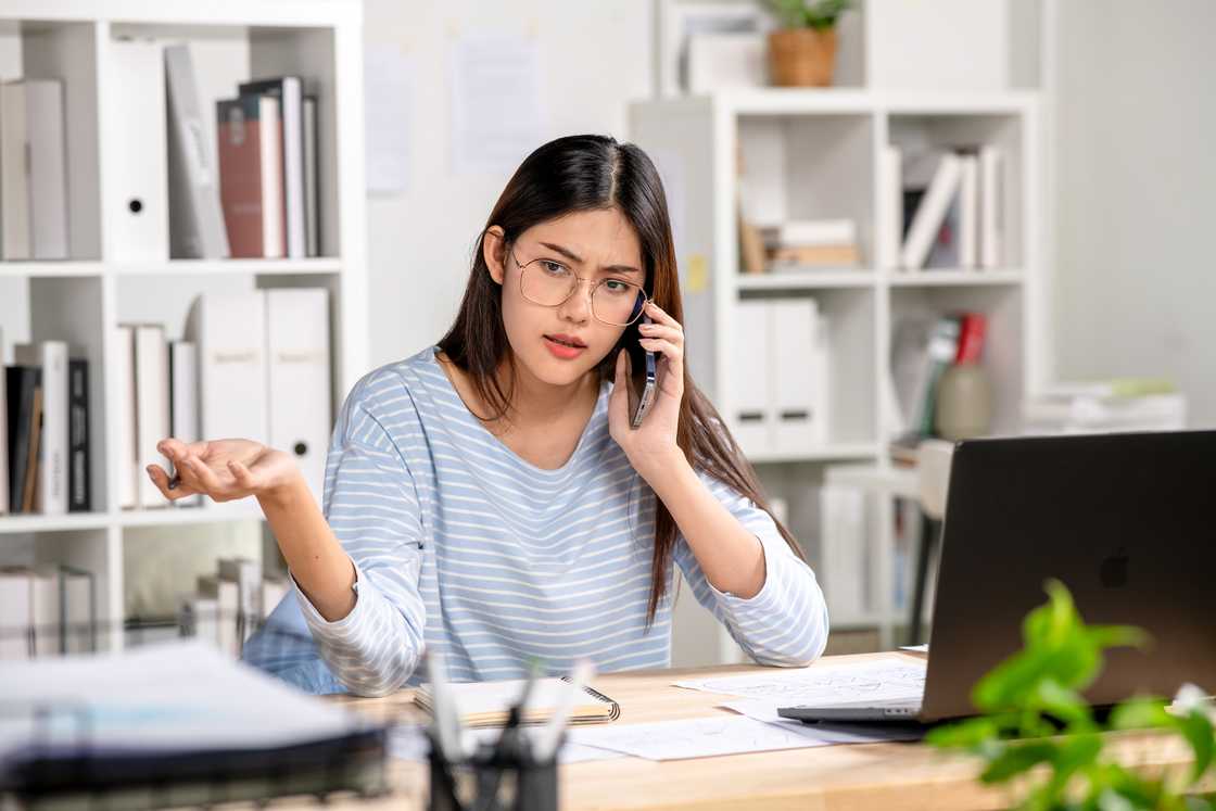 An upset young woman answering a phone call An upset young woman answering a phone call