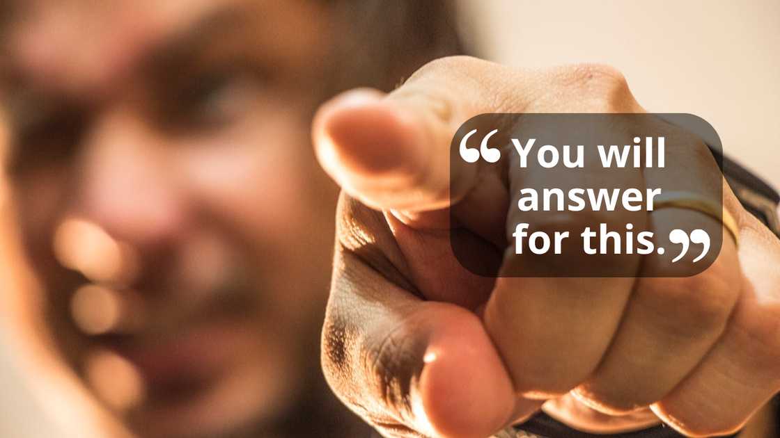 A person pointing directly at the camera with an intense, confrontational gesture.