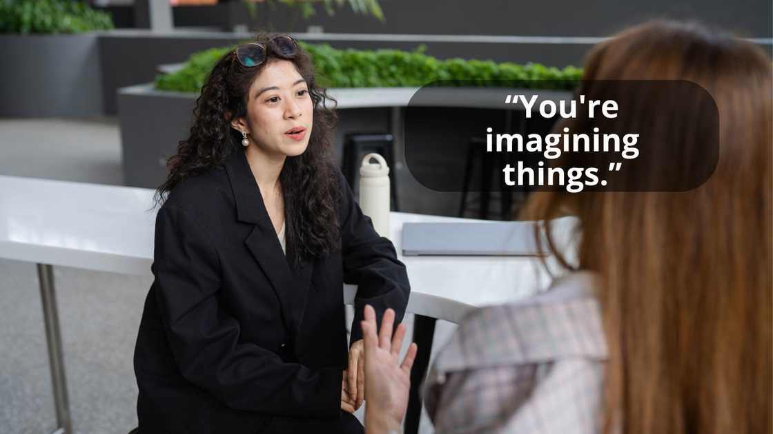 Young women talking while sitting at an outdoor cafe.