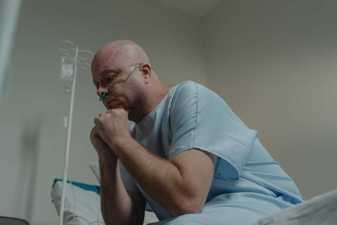 A man, deep in thought, sits on the hospital bed. A man, deep in thought, sits on the hospital bed.