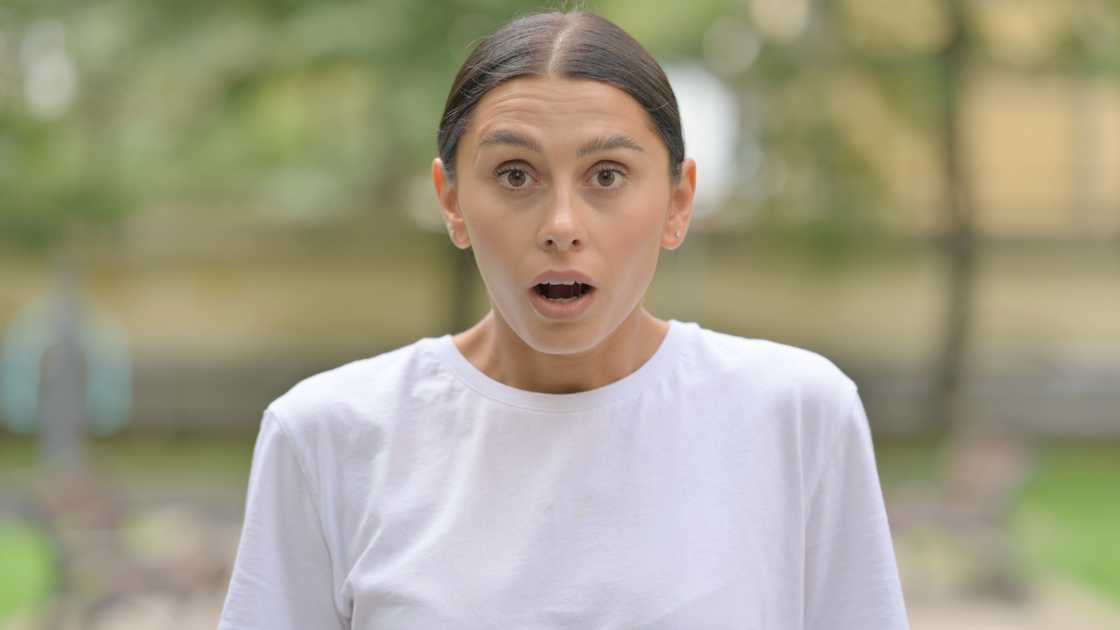 A shocked woman standing outdoor