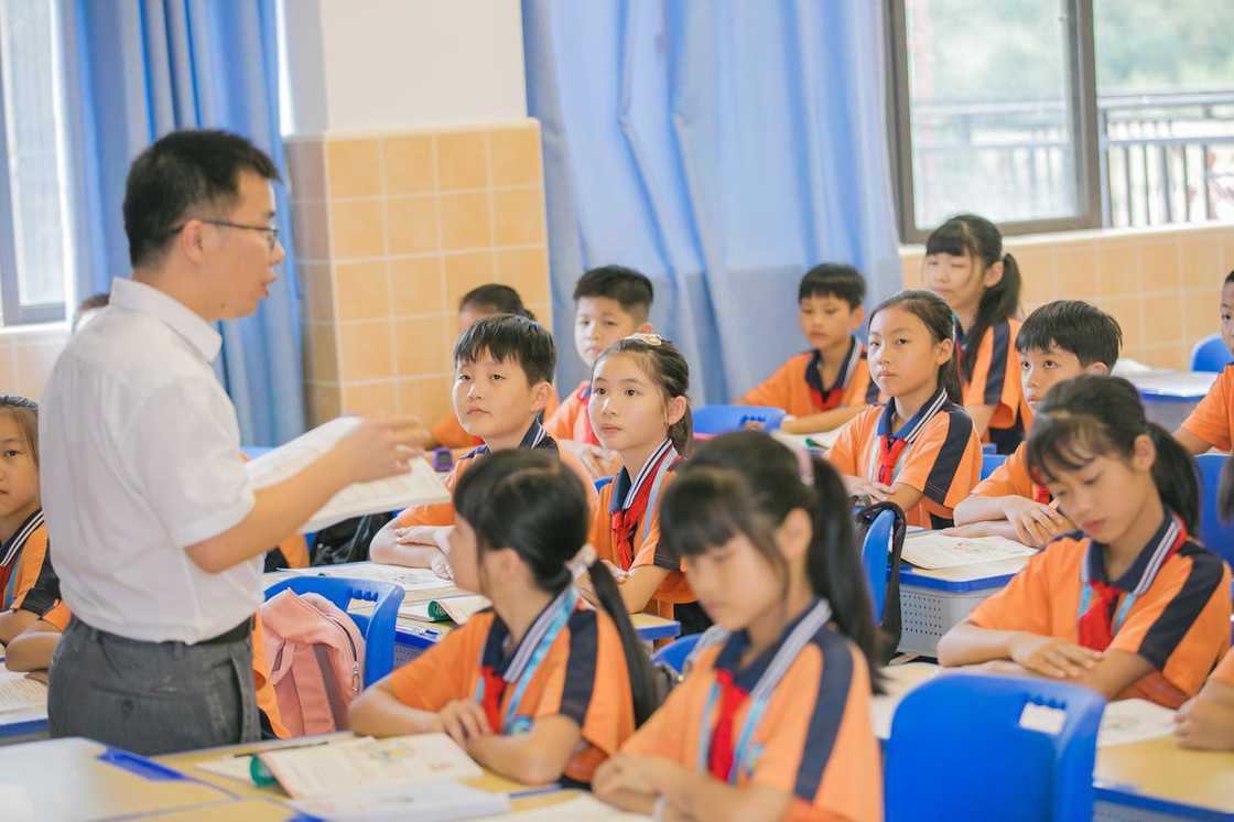 A teacher encourages pupils during a class session.