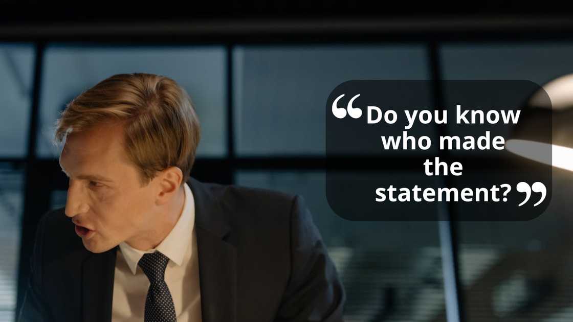 A man speaks while standing at a desk. A man speaks while standing at a desk.