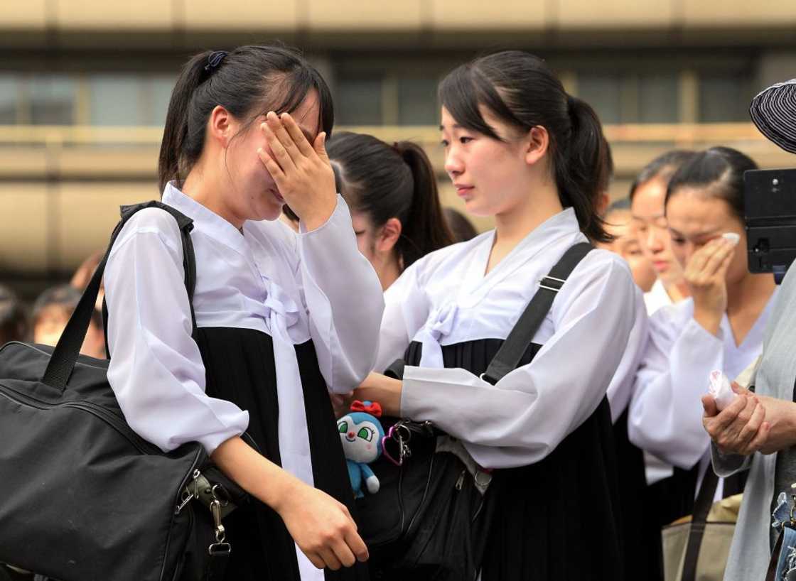 High school crying, consoled by mates.