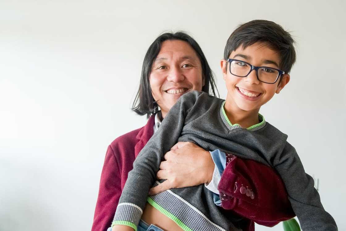 A father carries his young son. A father carries his young son.