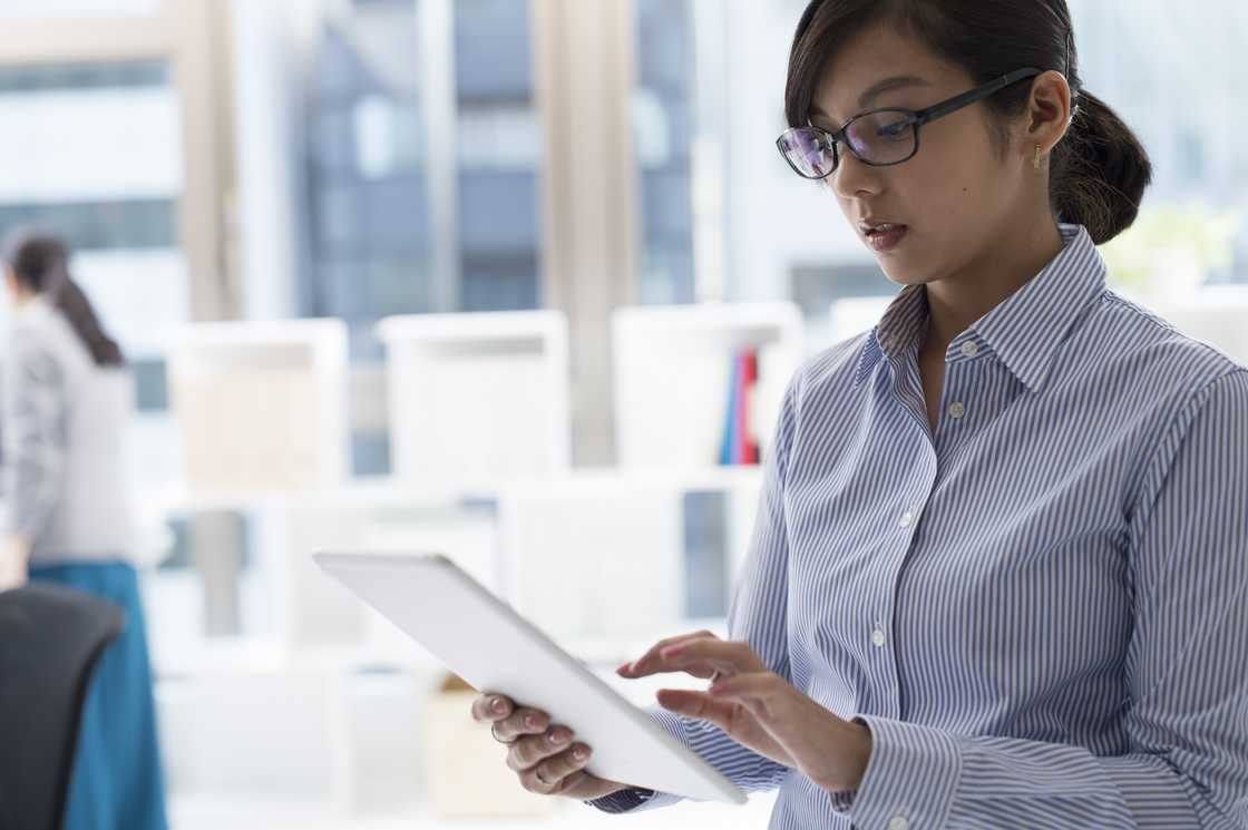 A lady scrolls through her tablet