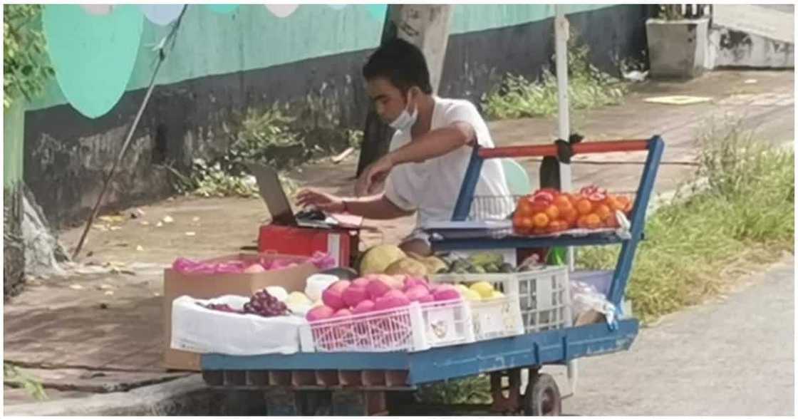 Fruit vendor na naka-laptop habang naglalako, dumadalo pala ng kanyang online classes Fruit vendor na naka-laptop habang naglalako, dumadalo pala ng kanyang online classes
