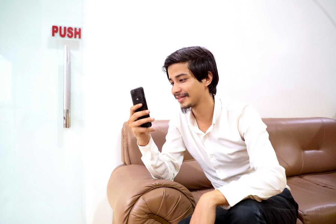 a busy man looking at his phone smiling