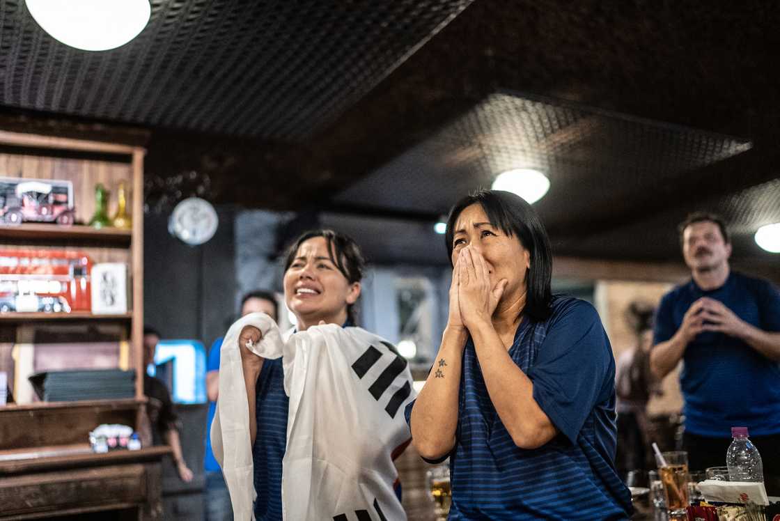 Soccer fans shouting in a viewing hall
