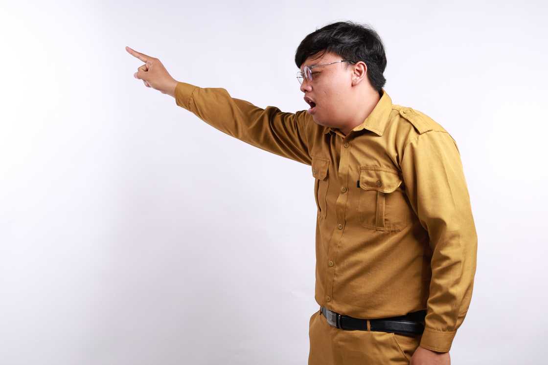 An angry police officer standing while pointing sideways