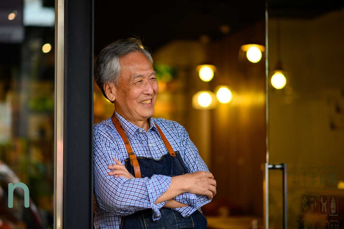 An elderly man working in a cafe An elderly man working in a cafe
