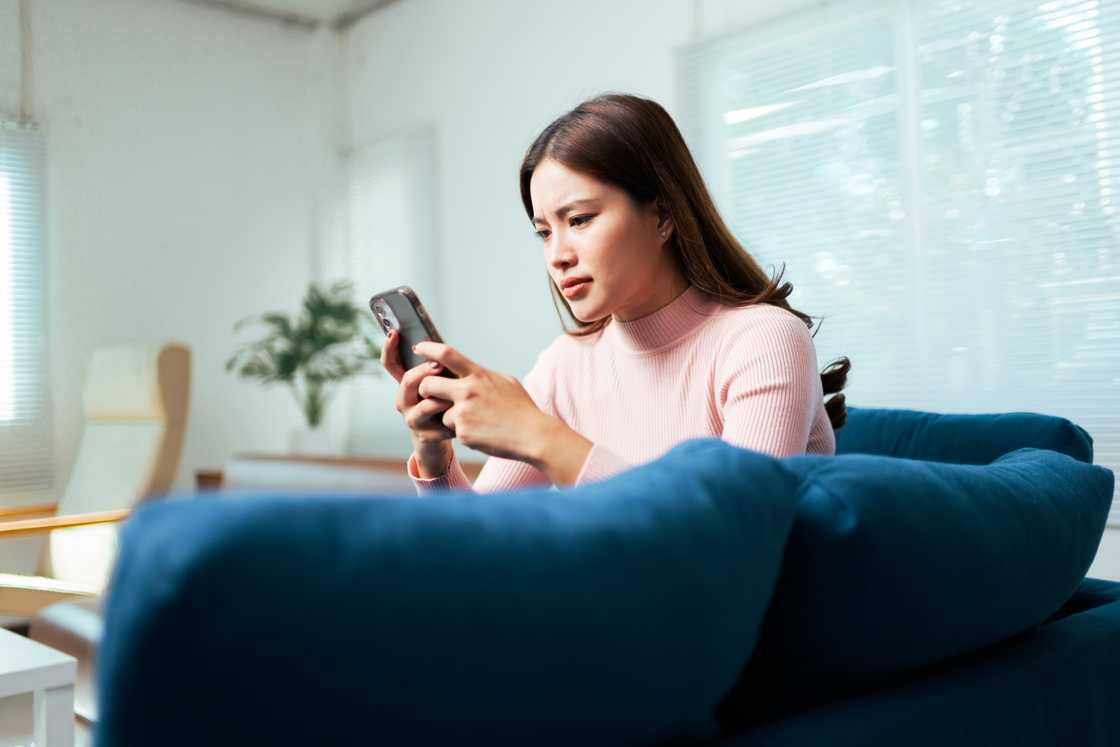 A tensed llady is scrolling on her phone A tensed llady is scrolling on her phone