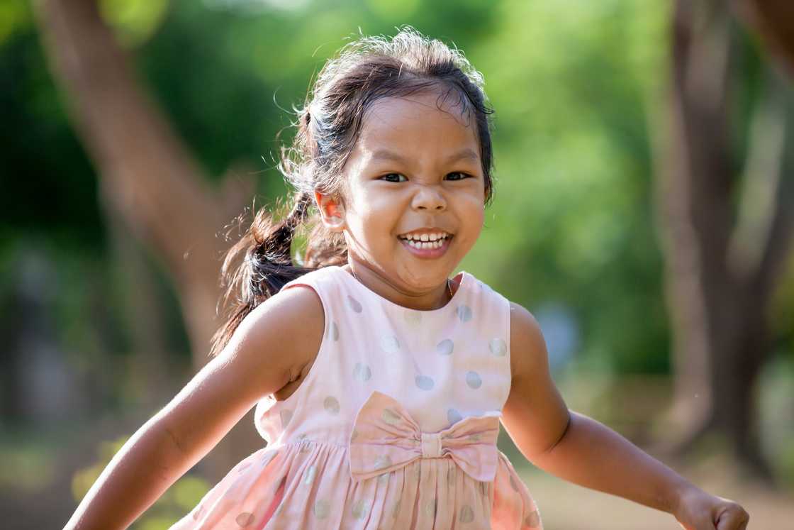 A young gril running in the patk